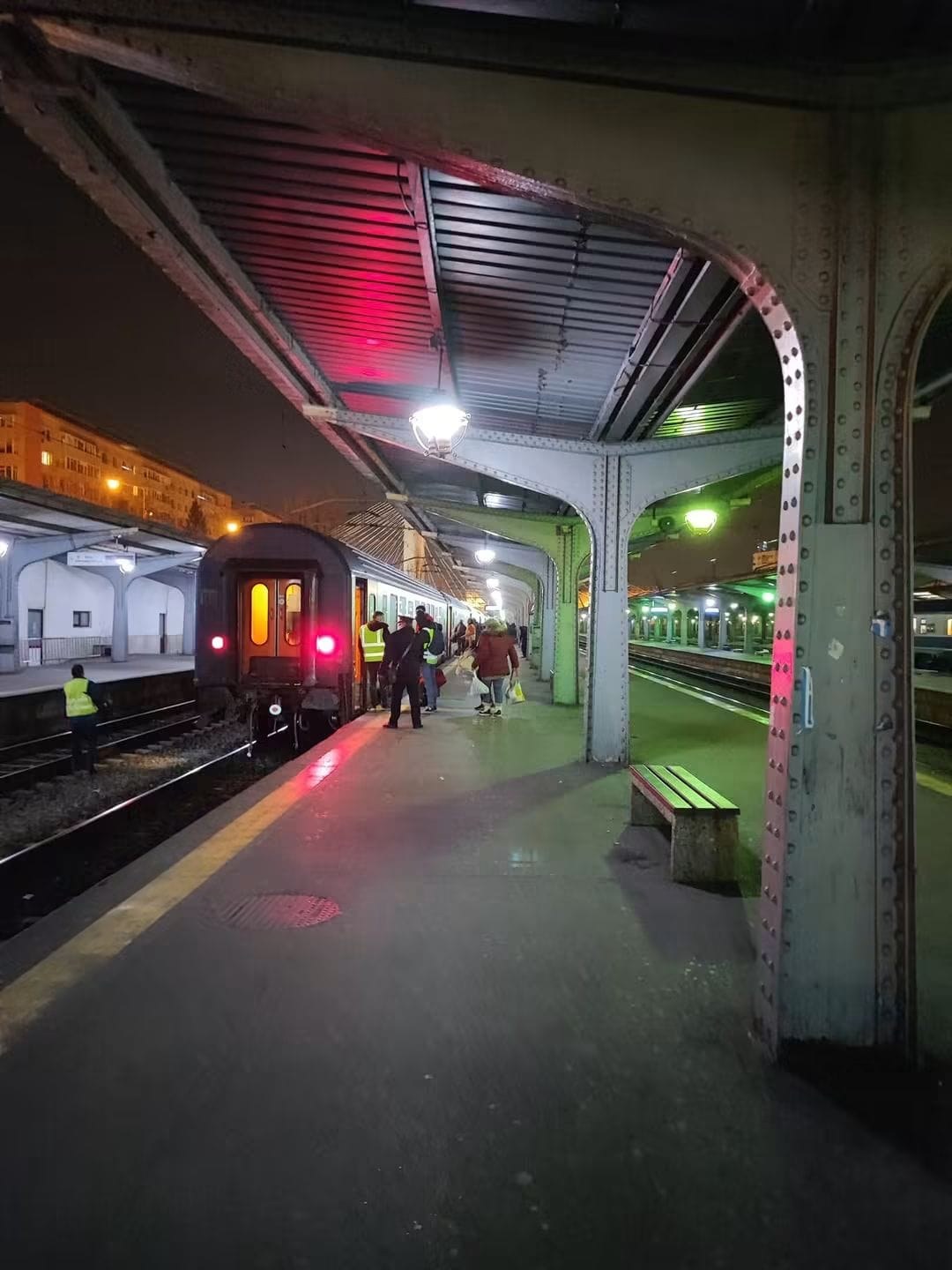Tren și voluntari pe peronul gării, seara